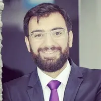 Mehmet Sadık Sunay, smiling, wearing glasses, a dark suit and a purple tie